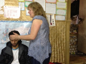 Night Hike casualty: A volunteer tries Reiki on Doc Mexico, stricken with Dengue fever.